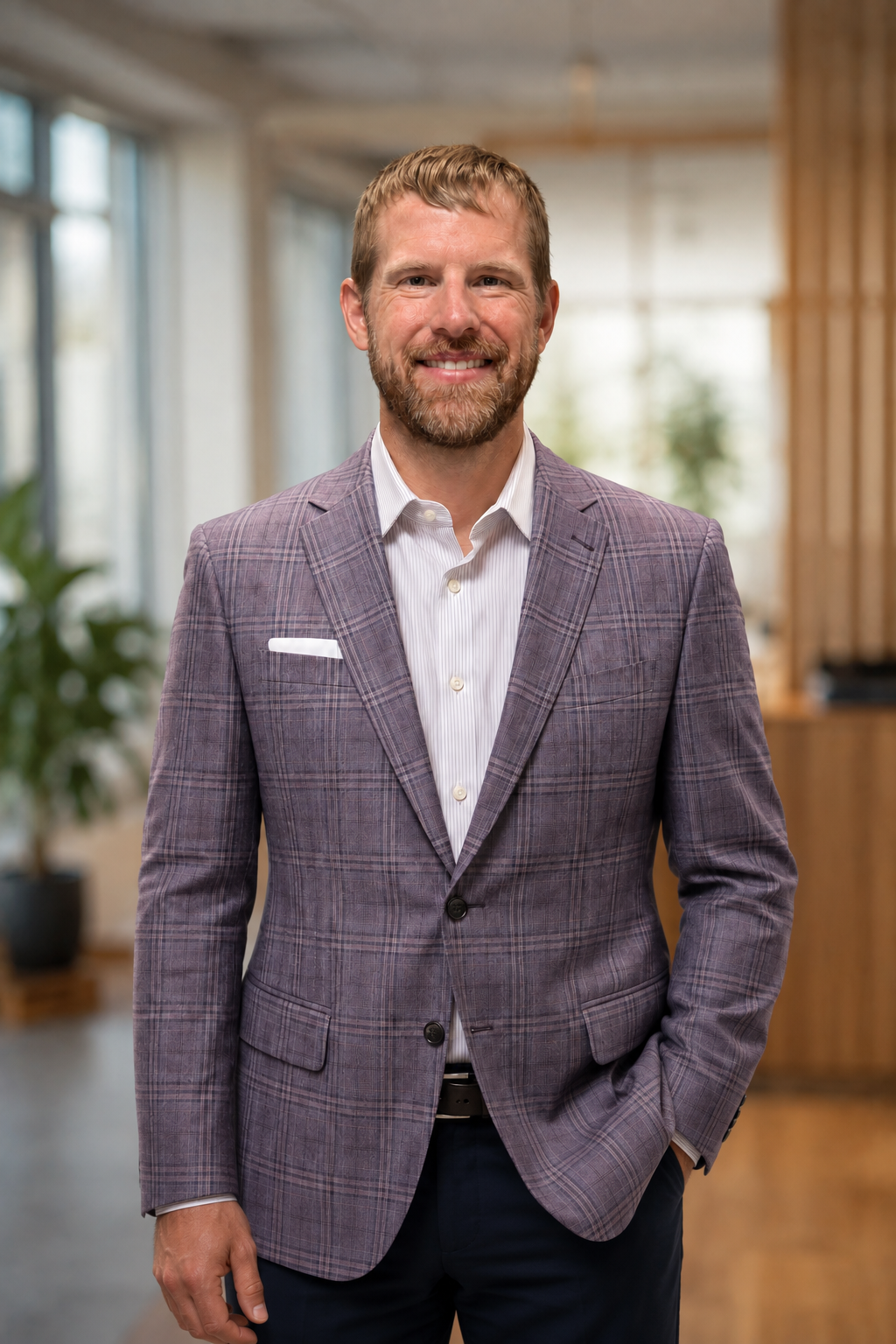 Bryan Burke smiling in a checked jacket in an office